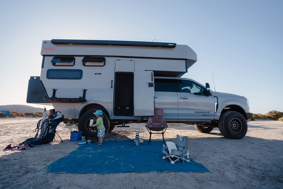Rossmonster Baja Trail parked at a beach campsite with the CGear Sand Mat creating a patio in front of it